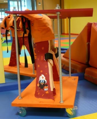 Custom children's stander, decorated, with trunk and leg supports on a wheeled platform